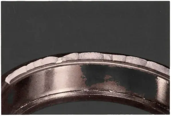 Ribs chipped by driving one race in place through the other race and the rolling elements; cracks start on the inside of the rib.