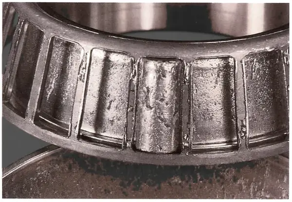 The rotating ring and rollers also carry an even pattern when the bearing has run tight; the cage lipping seen here came later, after spalling made the bearing loose.