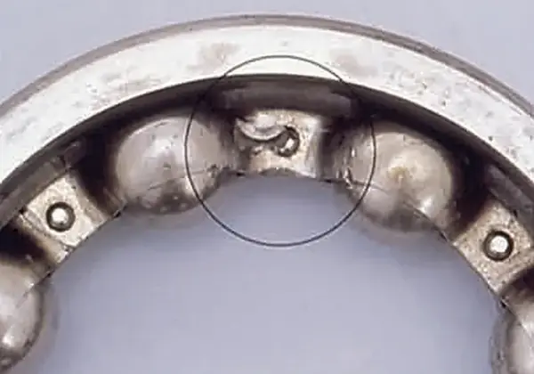 Dents in a ball bearing cage from an impact.