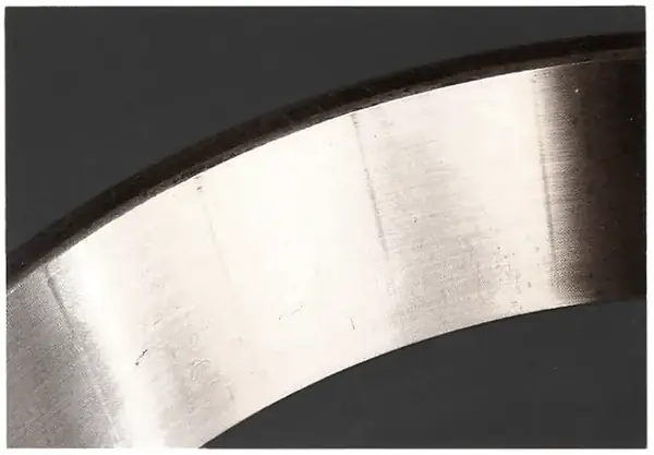 A cup cocked in its bore: raceway smeared and brinelled by heavy misaligned pressure on the near side.