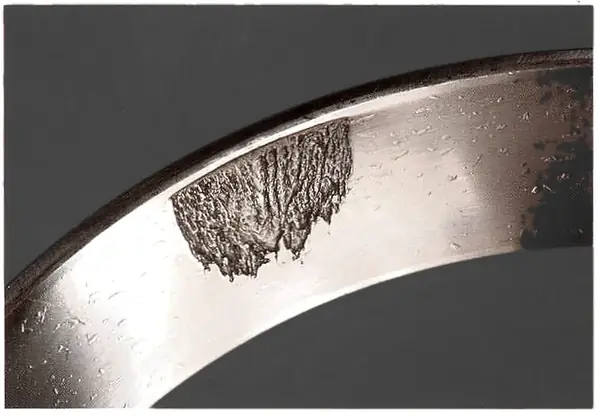 Spall in a localised area, with another about 120 degrees round, where housing high spots stopped the ring seating.