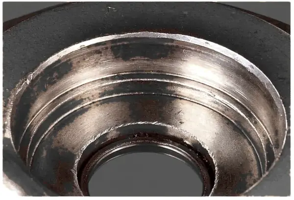 The same bearing was removed with a chisel; chisel marks in the housing raise high spots and reduce clearance.