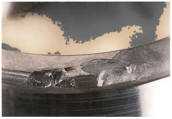 Impact on the rib face with local heat colour from the sliding action of the blow.